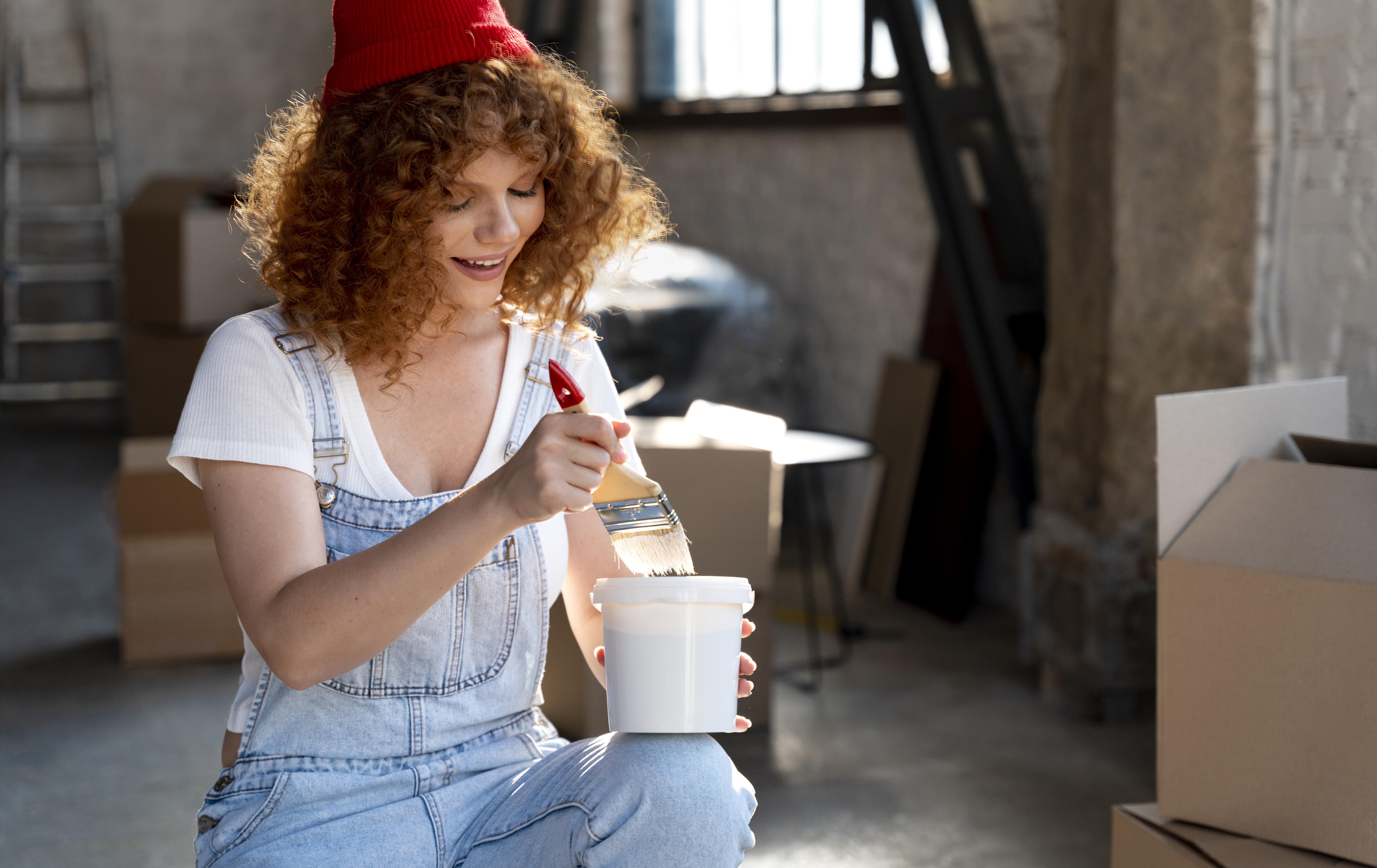 Red haired white women decorating her house ready to be sold in Nuneaton